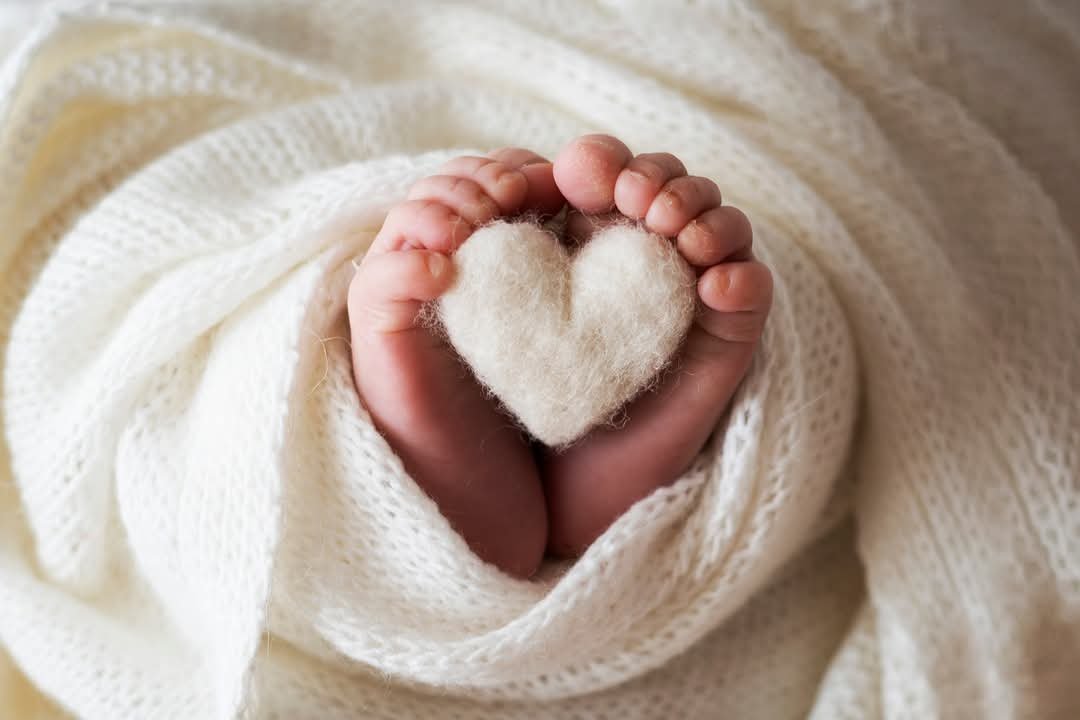Piedini di un neonato avvolto in una coperta